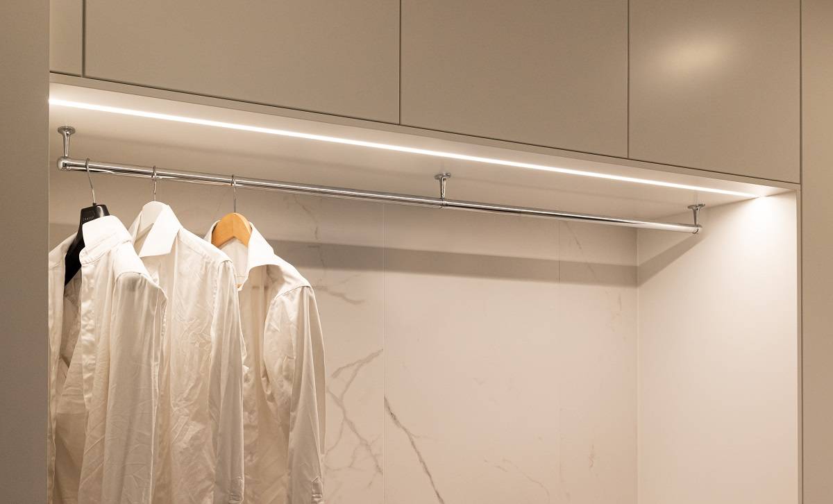 Led osvětlení v zapuštěném hliníkovém profilu s neutrální teplotou barvy světla v horní části otevřené skříně.